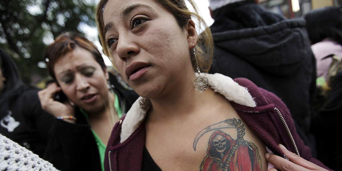 A woman shows her tattoo of La Santa Muerte (The Saint of Death) near her altar in Tepito in Mexico City