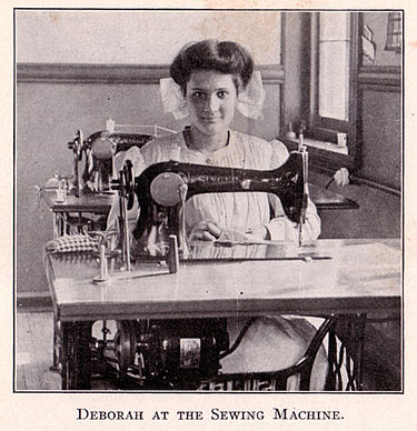 Эмма Волвертон, изображённая как Дебора Калликак, за швейной машинкой