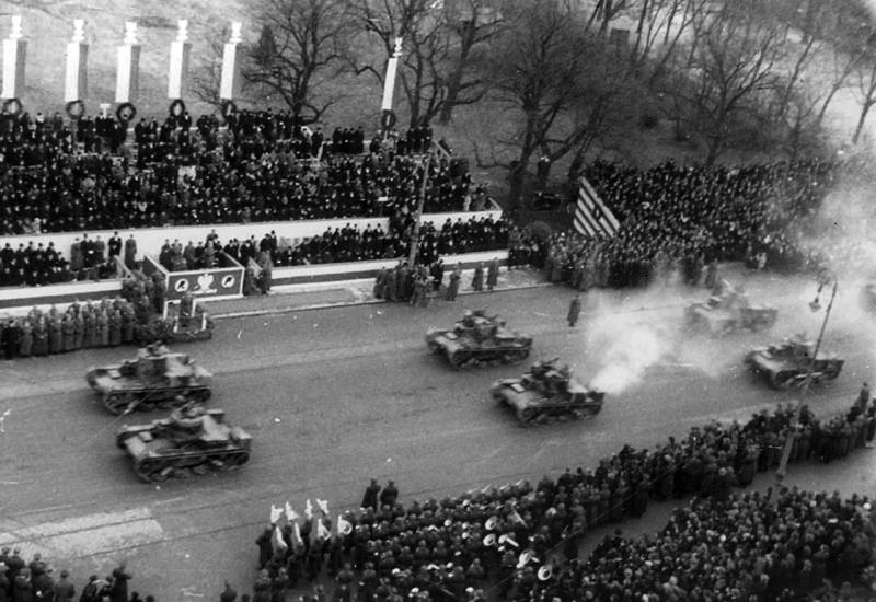Польские танки 7ТР проходят мимо главных трибун на параде «Дня независимости» в Варшаве 11 ноября 1938 года. Фотография примечательна тем, что польский парад особо привязывался к захвату Тешинской Селезии месяцем ранее. Проехавшие на параде танки участвовали в захвате Чехословакии, а в Германии накануне в ночь с 9 на 10 ноября 1938 года произошла так называемая «хрустальная ночь», первая массовая акция прямого физического насилия по отношению к евреям на территории Третьего Рейха.